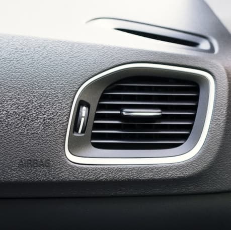 Technician servicing a vehicle air conditioning system