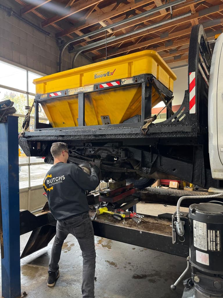Butchs Automotive technician working under a lifted fleet truck
