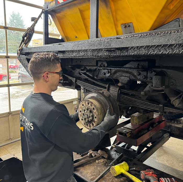 Technician inspecting a brake rotor and caliper
