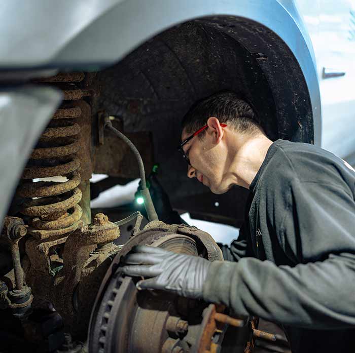 Technician working on a truck’s suspension components